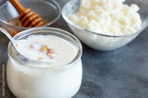 Fotografie Fermented yogurt kefir in small bottles with cherries and walnuts