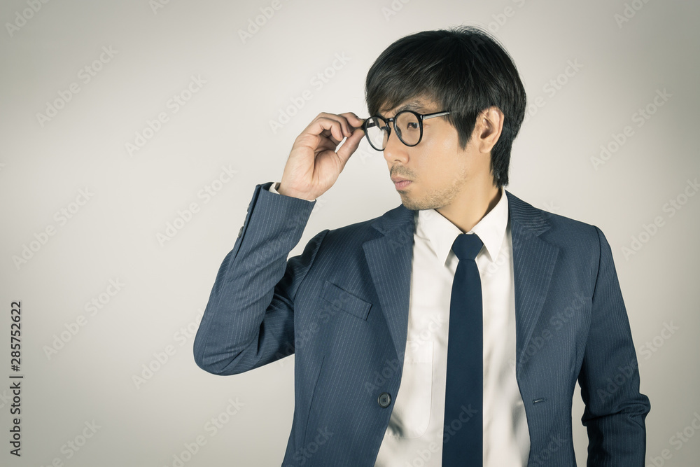Young Asian Portrait Businessman Touch Eyeglasses and Look Below in Vintage Tone Young Asian Portrait Businessman Touch Eyeglasses and Look Below in Vintage Tone