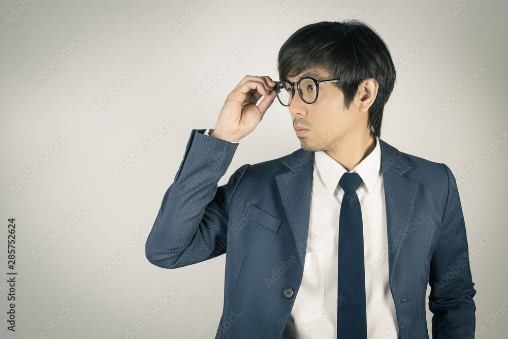 Young Asian Portrait Businessman Touch Eyeglasses and Look Beside in Vintage Tone Young Asian Portrait Businessman Touch Eyeglasses and Look Beside in Vintage Tone