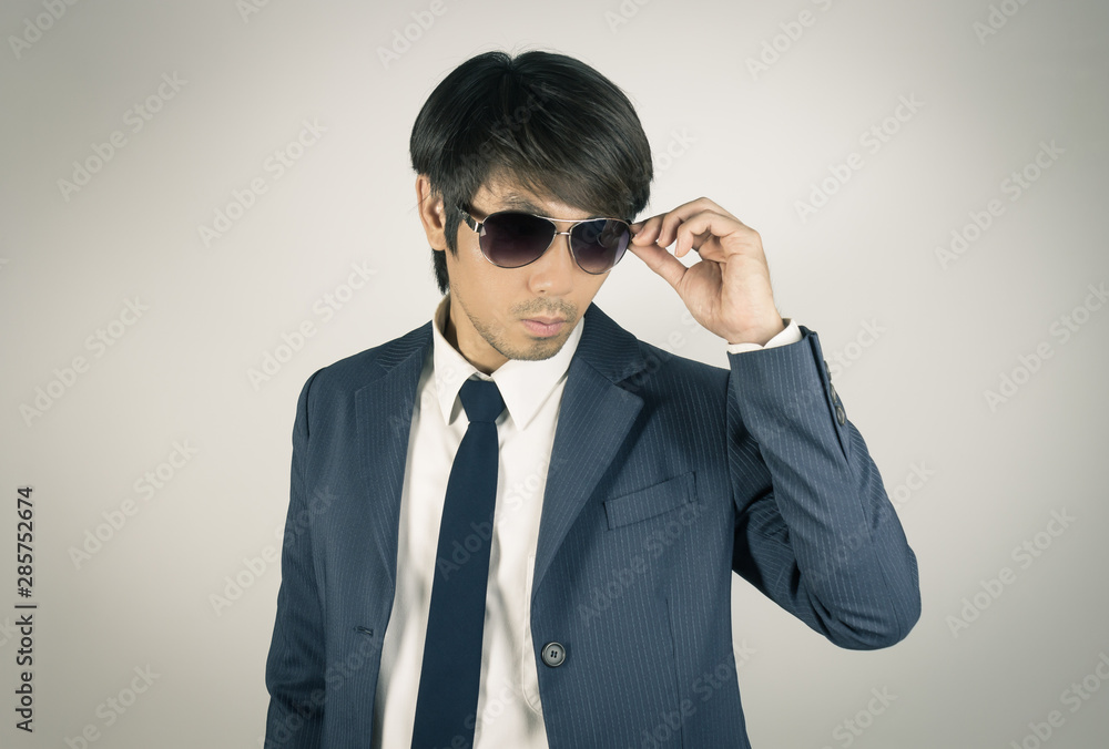 Young Asian Portrait Businessman Touch Sunglasses and Look Below in Vintage Tone