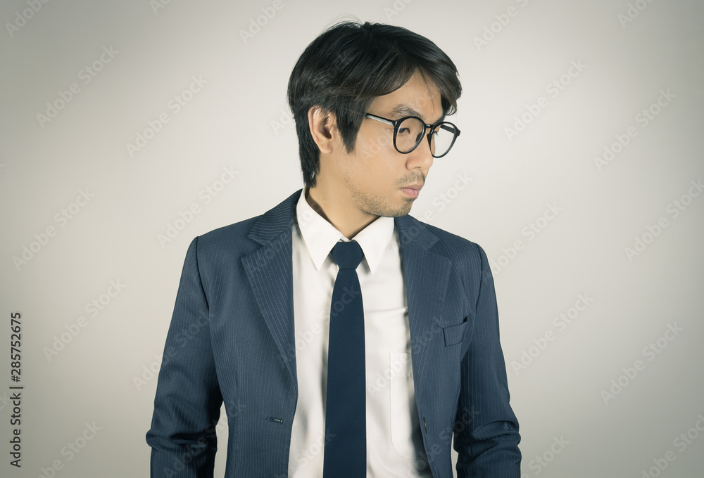 Young Asian Portrait Businessman Wear Eyeglasses and Look Below In Vintage Tone
