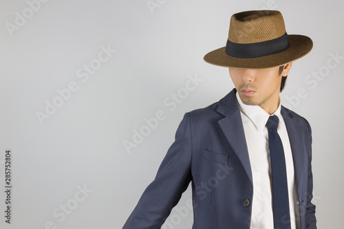 Young Asian Portrait Businessman in Navy Blue Suit Wear Hat and Look Below at Right Frame