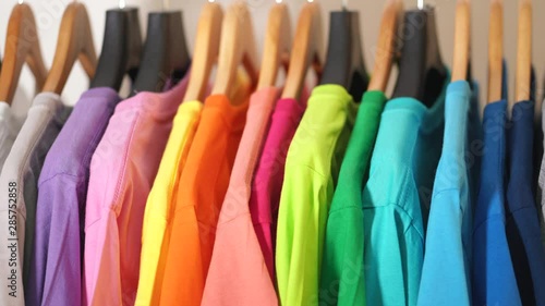 Close up of Colorful t-shirts on hangers, apparel background