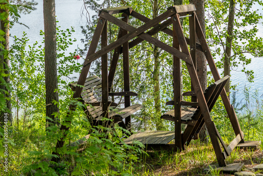 A wooden swing on the shores of the Saimaa lake in Finland A wooden swing on the shores of the Saimaa lake in Finland