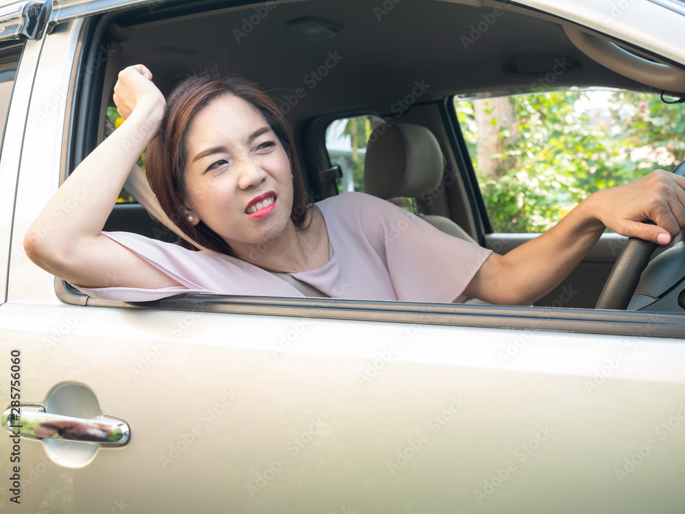 Unhappy asian woman while driving in traffic jam.