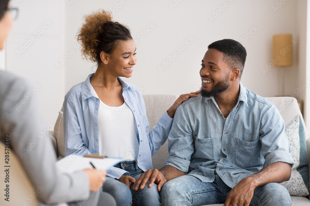 Afro Spouses Sitting At Marriage Counselor's Office After Happy Reconciling Afro Spouses Sitting At Marriage Counselor's Office After Happy Reconciling