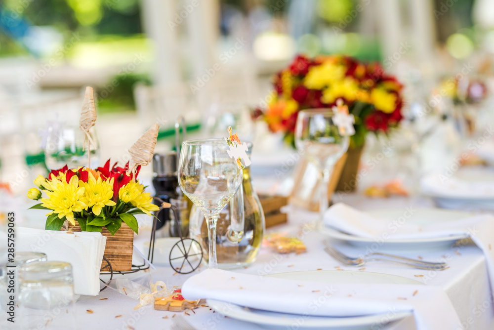 Wedding table set up decoration made of red and yellow fresh flowers. Rustic/ garden wedding decoration