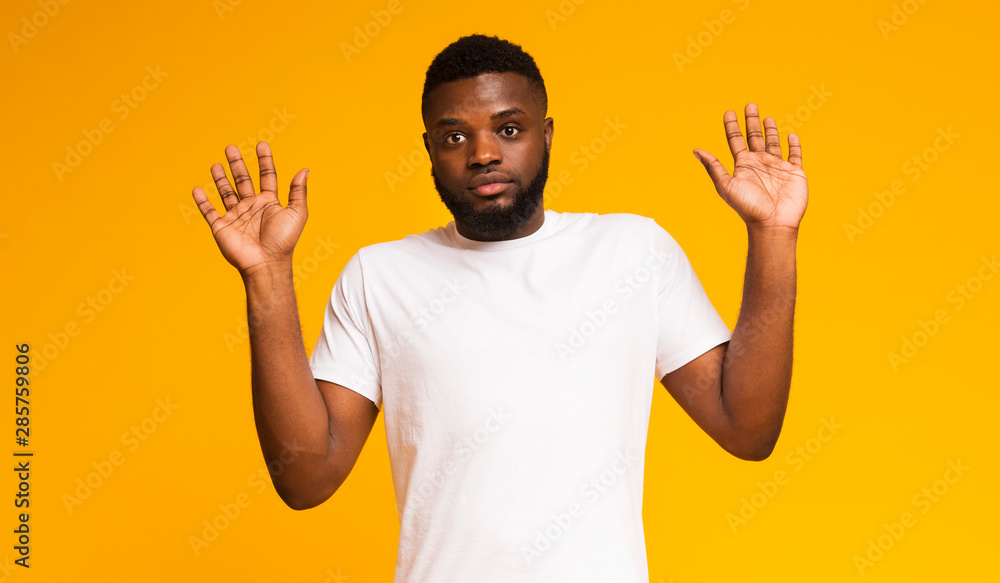 Confused african american man raising his hands, looking at camera Confused african american man raising his hands, looking at camera