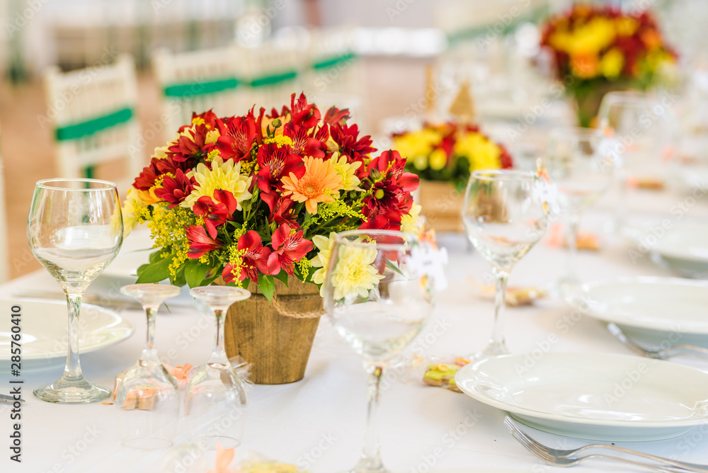 Wedding table set up decoration made of red and yellow fresh flowers. Rustic/ garden wedding decoration Wedding table set up decoration made of red and yellow fresh flowers. Rustic/ garden wedding decoration
