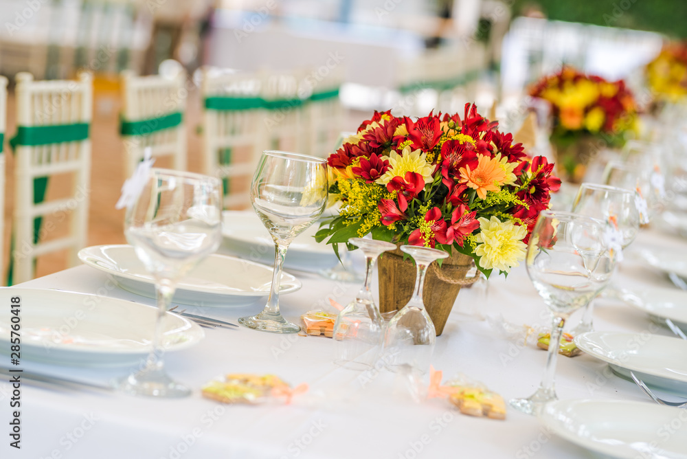 Wedding table set up decoration made of red and yellow fresh flowers. Rustic/ garden wedding decoration Wedding table set up decoration made of red and yellow fresh flowers. Rustic/ garden wedding decoration