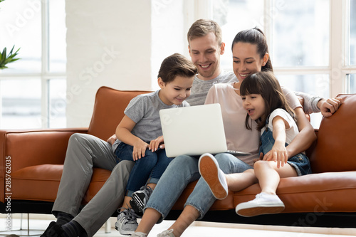 Happy family enjoy using laptop make online call at home
