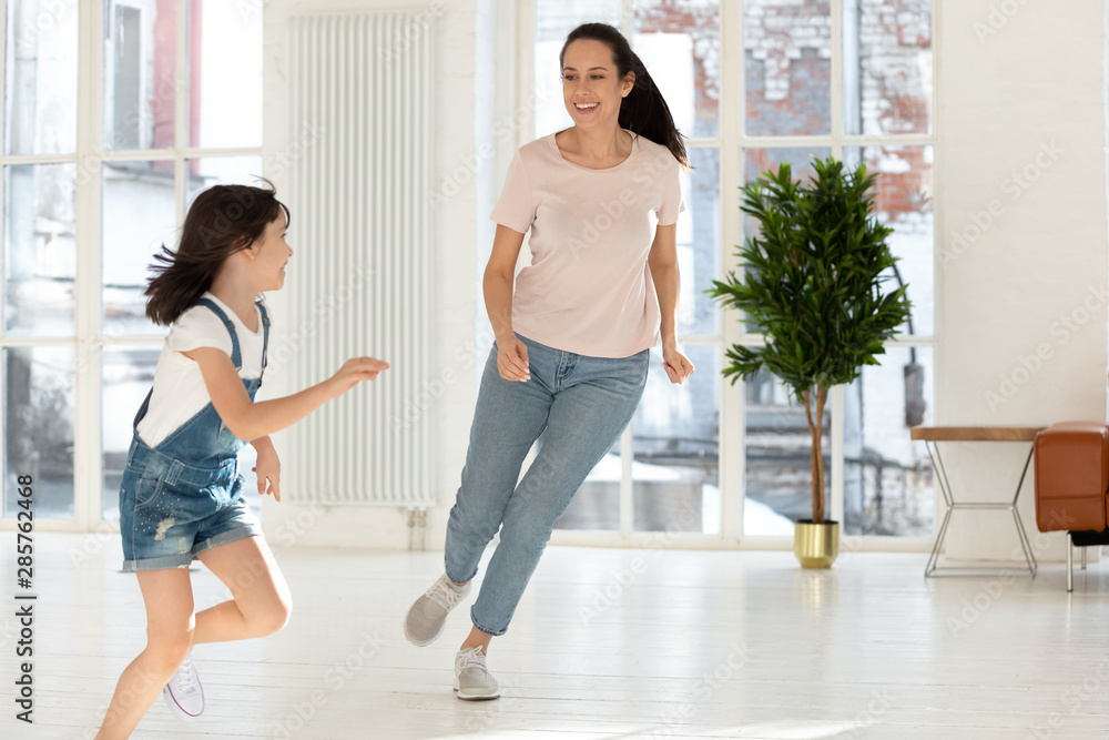 Obraz premium Happy mom and kid daughter playing tag and touch game