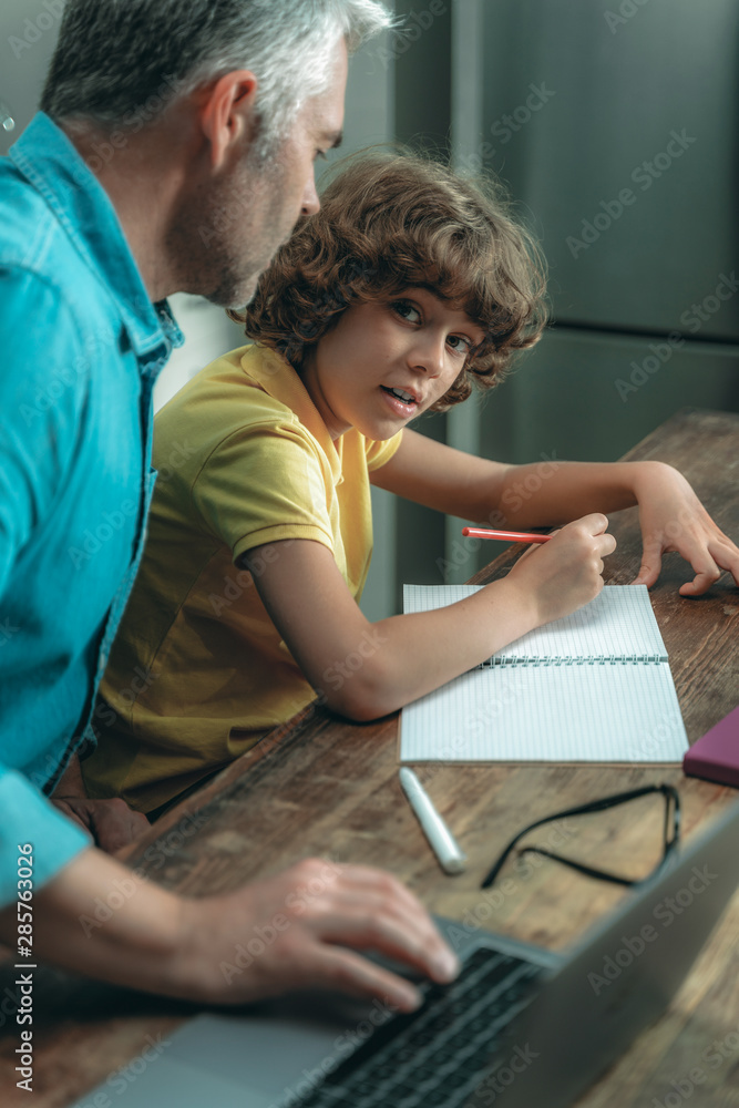 Fototapeta premium Father and liitle kid making school homework together