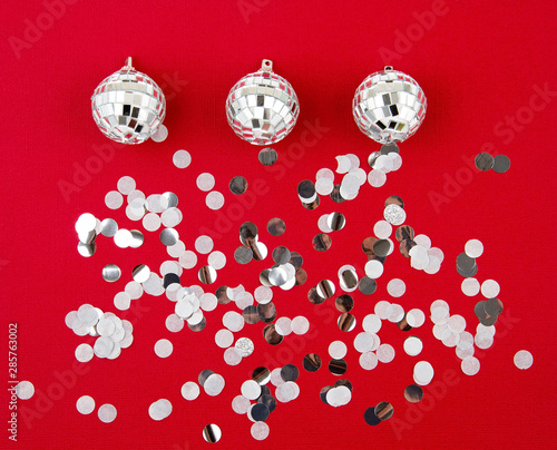 Disco balls and confettie over the red background. Party nightclub, christmas, new year celebration photo