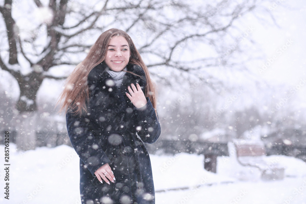 Girl in a winter park in snowfall Girl in a winter park in snowfall