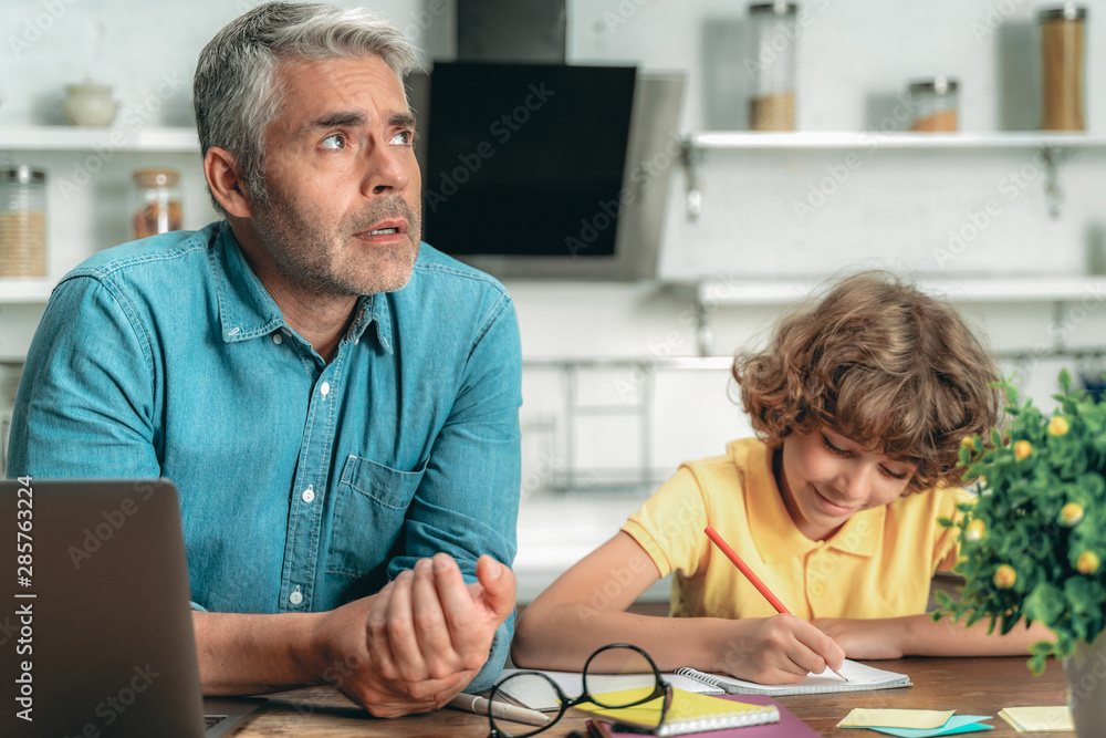 Father making school homework together with little kid Father making school homework together with little kid