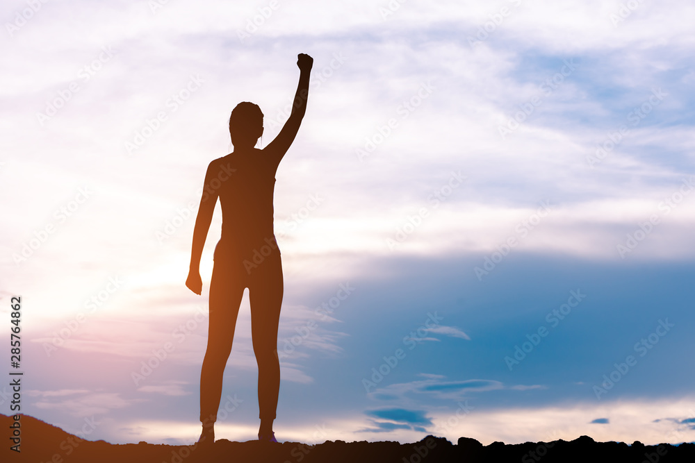 Fototapeta premium silhouette woman standing and rising hands with sun lighting