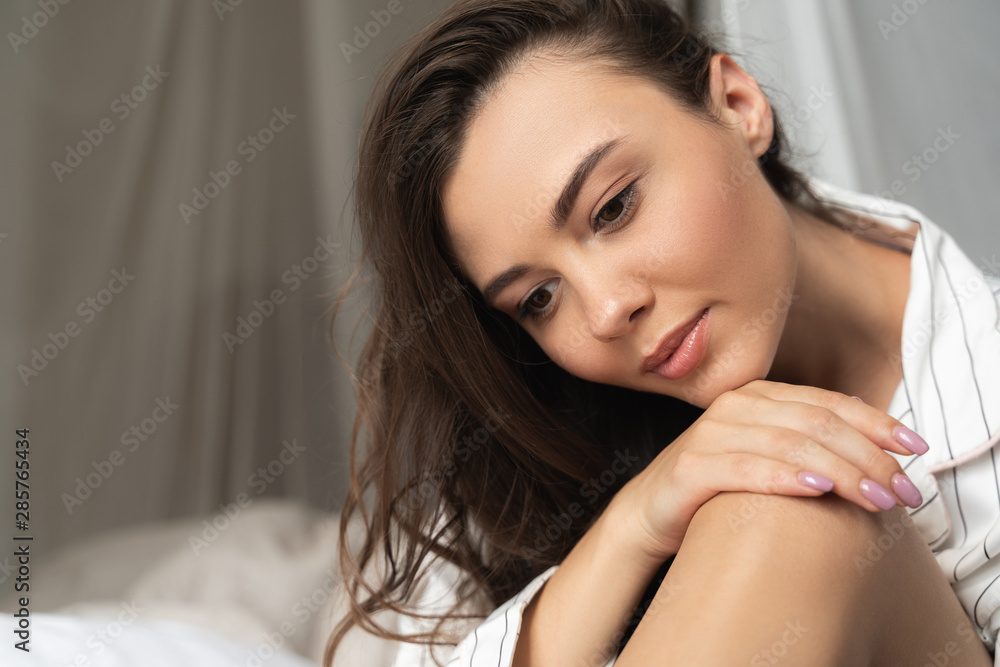 Beautiful young woman resting her chin on hand Beautiful young woman resting her chin on hand