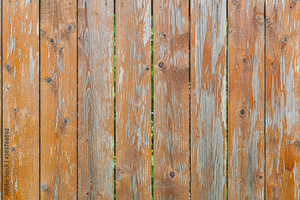 Close-up of a brown vertical wooden wall painted a very long time and the paint peeled off. Brown texture background Close-up of a brown vertical wooden wall painted a very long time and the paint peeled off. Brown texture background