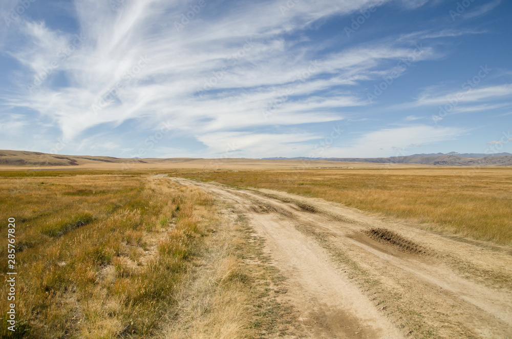 Wildlife Altai. The road, mountains and sky with clouds in summer