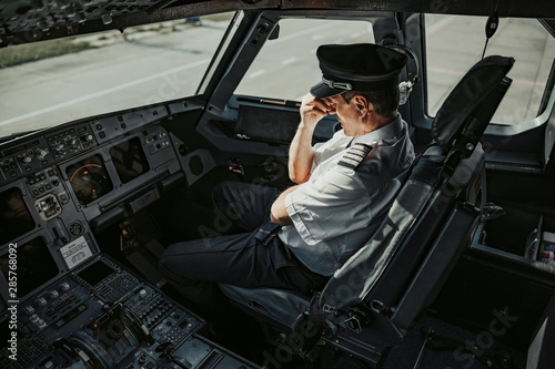 Caucasian man in uniform showing pain and touching his forehead