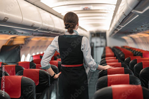 Konstfotografi Caucasian stewardess is on duty on board of airliner