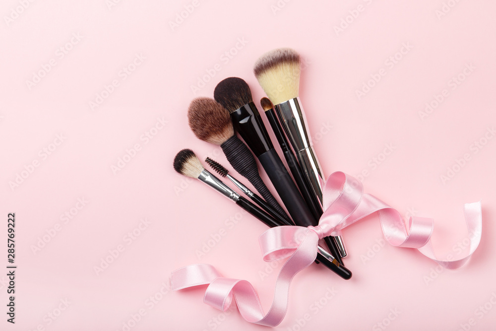 Set of brushes for make up on pink background. Women's secrets. Tools for make up artist with decorative cosmetics Set of brushes for make up on pink background. Women's secrets. Tools for make up artist with decorative cosmetics