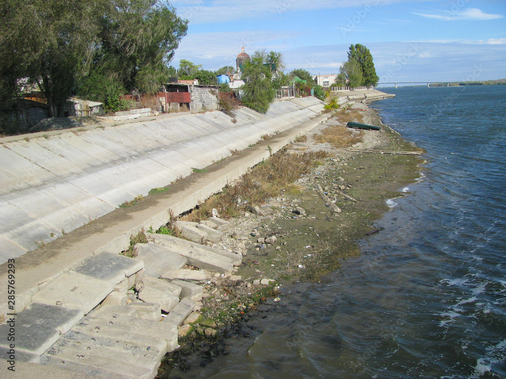 Astrakhan, bank of the Volga River reinforced with concrete slabs, recession of water exposed a sandy bottom