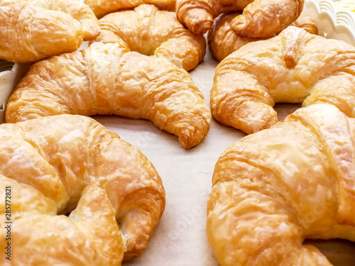 Closeup and crop of Croissant on bakery paper in a bakery shop.