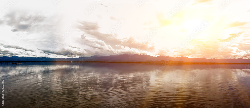 Landscape and panorama view of Phayao big swamp in sunset day on sun flare with clouds sky background.