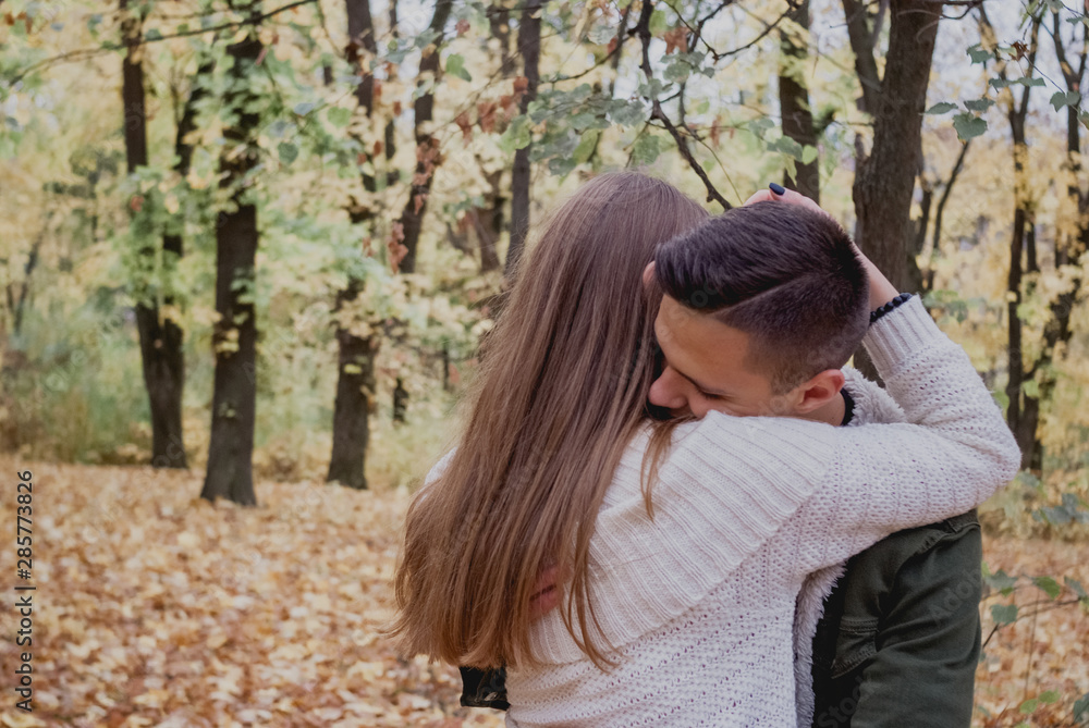 Happy couple in the autumn park have a fun time. Colored autumn Happy couple in the autumn park have a fun time. Colored autumn