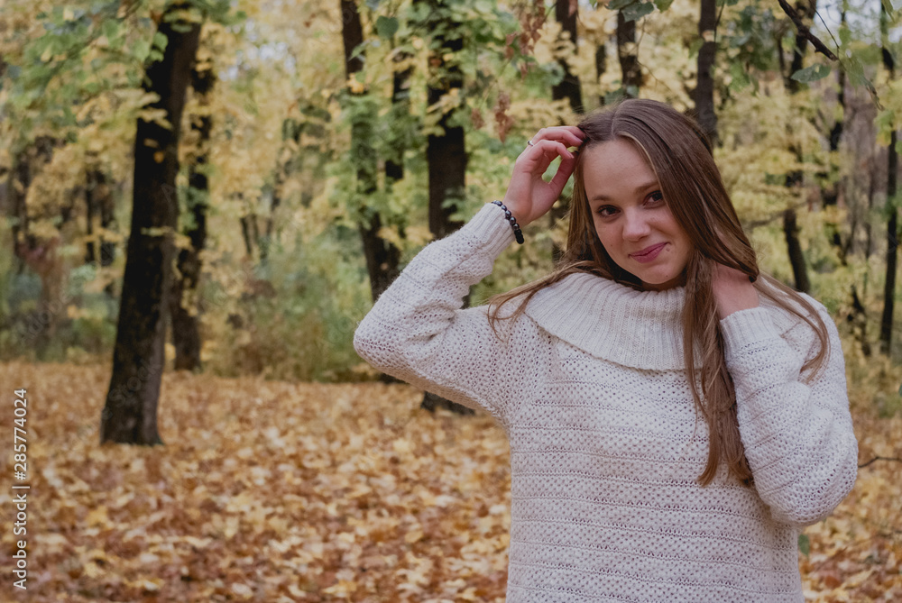 Portrait of a beautiful, dreamy and happy girl with long wavy hair in knit sweater autumn. Nice weather Portrait of a beautiful, dreamy and happy girl with long wavy hair in knit sweater autumn. Nice weather