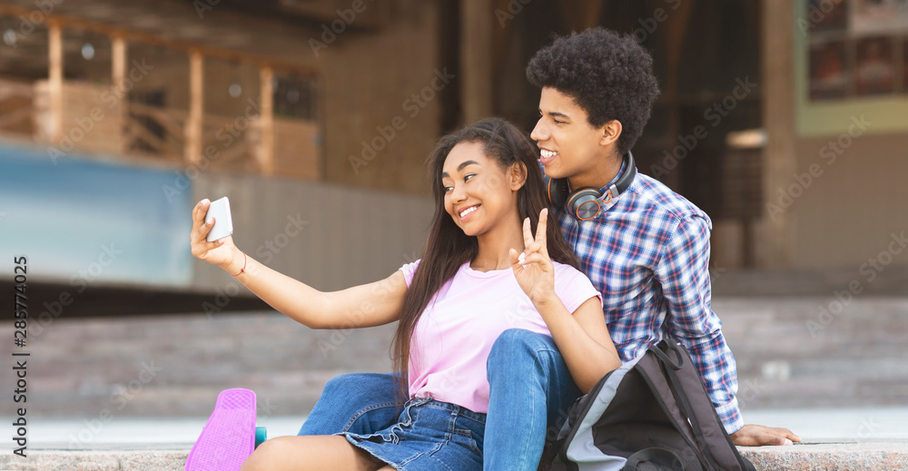 Fototapeta premium Young couple smiling and taking selfie outdoors