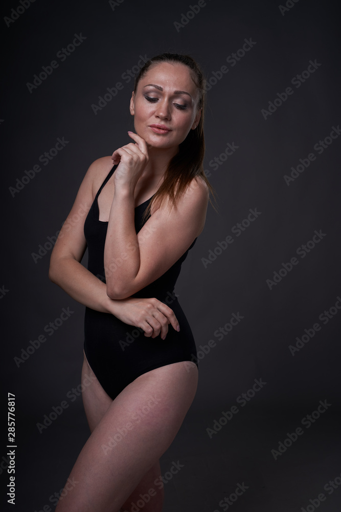 Obraz premium flexible sexy girl poses on a black grey background in the fitting clothes baud