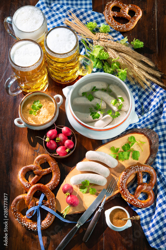 Bavarian sausages with pretzels, sweet mustard and beer mugs
