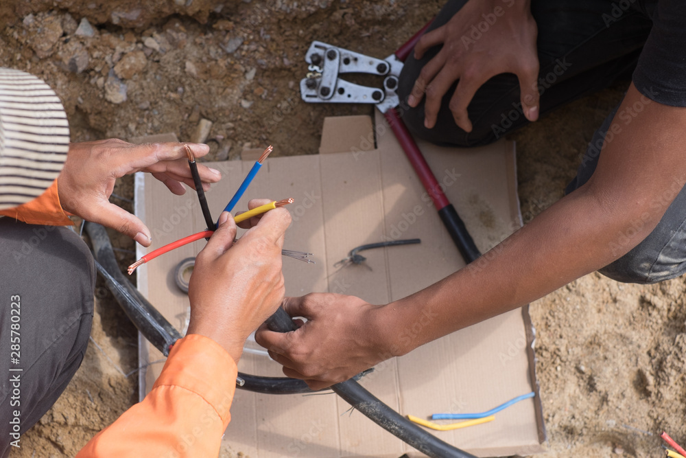Electrical engineer technician fixing high voltage underground cable wire installation...