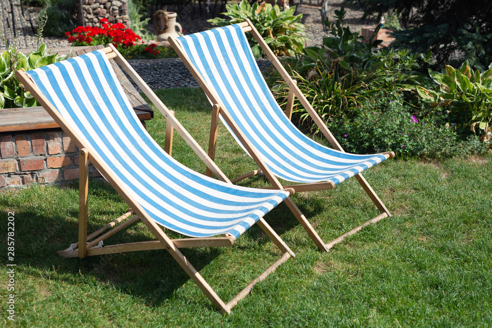 Deckchair chaise chair in café garden park gras, with blue red stripes relax Deckchair chaise chair in café garden park gras, with blue red stripes relax