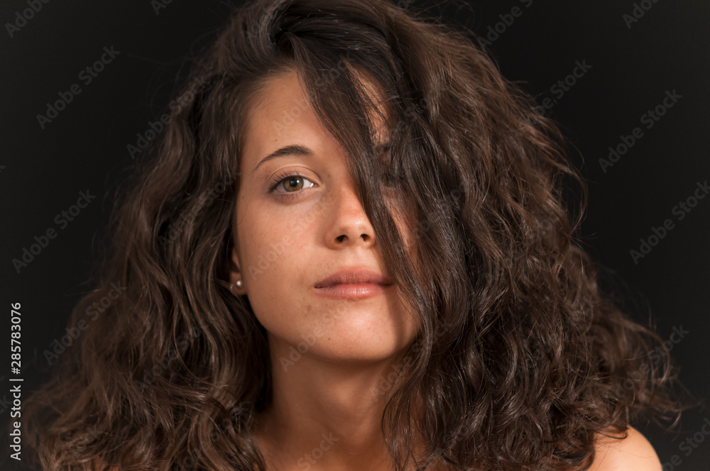 Young brunette girl photographed in studio with black background Young brunette girl photographed in studio with black background