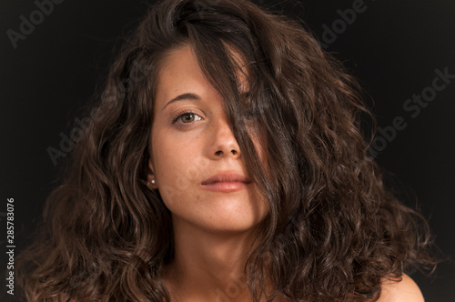 Young brunette girl photographed in studio with black background