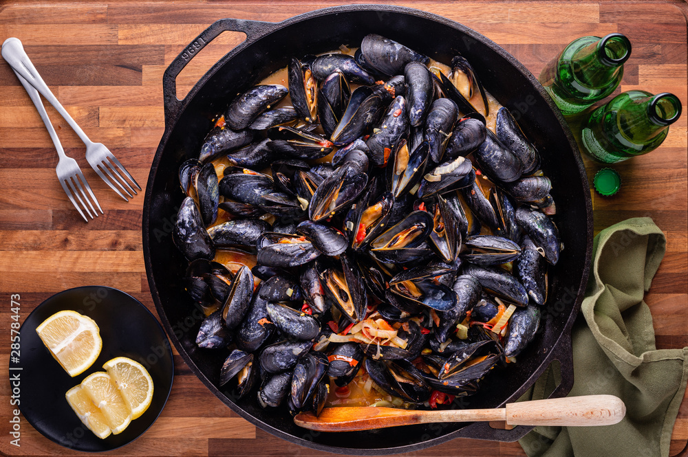 Large cast iron skillet of Mussels with roasted tomatoes, garlic, and fennel.