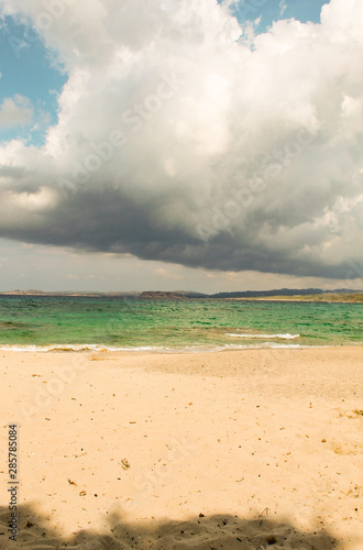 Plage sous gros nuage, sable et mer turquoise