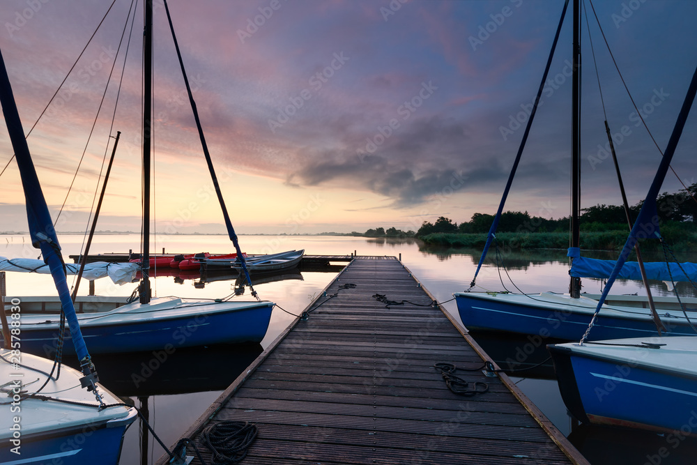 Fototapeta premium yachts on big lake harbor at sunrise