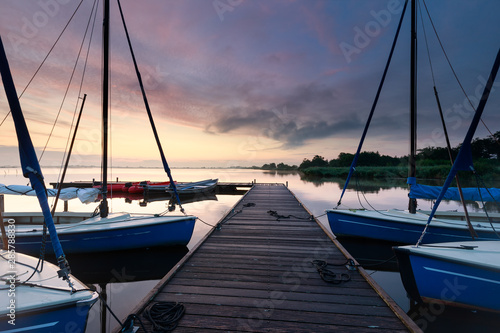 Fototapeta Naklejka Na Ścianę i Meble -  yachts on big lake harbor at sunrise
