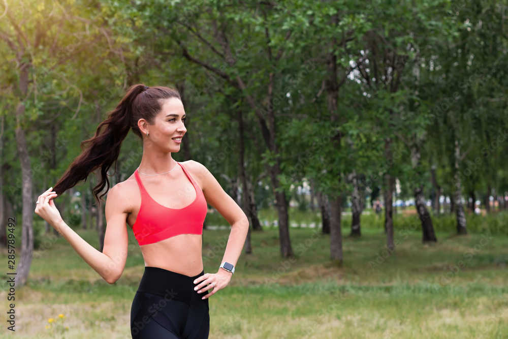 Young attractive smiling toned brunette woman working out outside in a park. Healthy lifestyle concept Young attractive smiling toned brunette woman working out outside in a park. Healthy lifestyle concept