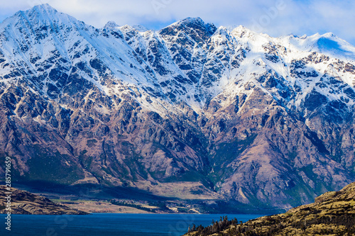 Balcony with view of cloudy blue sky over homes lake and snow capped mountain