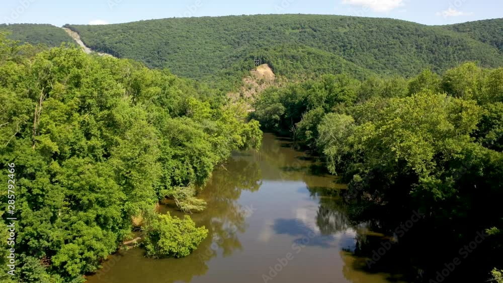 Ascending aerial view over Cacapon River with Appalachian Mountains and power line, fire line cut up one of the mountains. Ascending aerial view over Cacapon River with Appalachian Mountains and power line, fire line cut up one of the mountains.