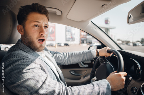 Young driver looks scared because of dangerous traffic situation that could cause sar accident.