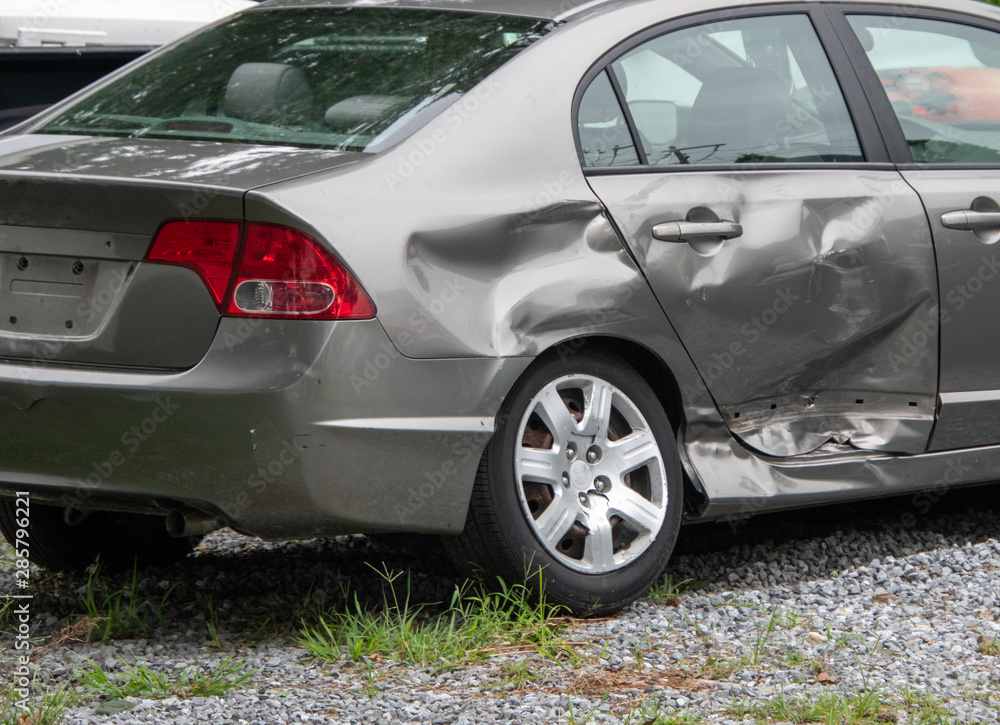 Damage to the rear panel, door and tire of a gray car due to an automobile accident