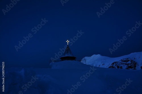 a illuminated cross on a mountain peak