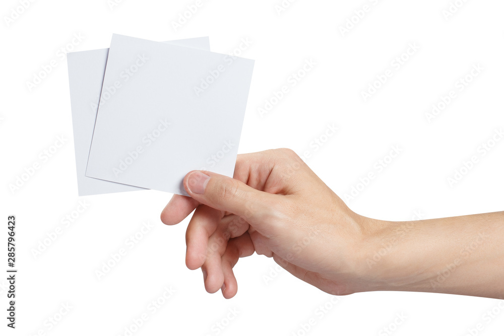 Male hand holding two square blank sheets of paper (tickets, flyers, invitations, coupons, etc.), isolated on white background Male hand holding two square blank sheets of paper (tickets, flyers, invitations, coupons, etc.), isolated on white background
